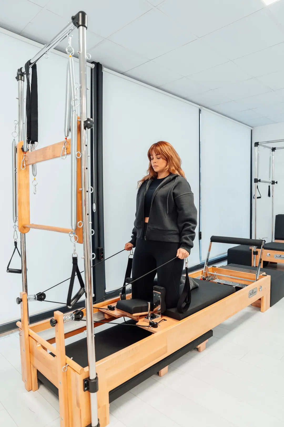 Pratiquante sur un reformer Pilates professionnel